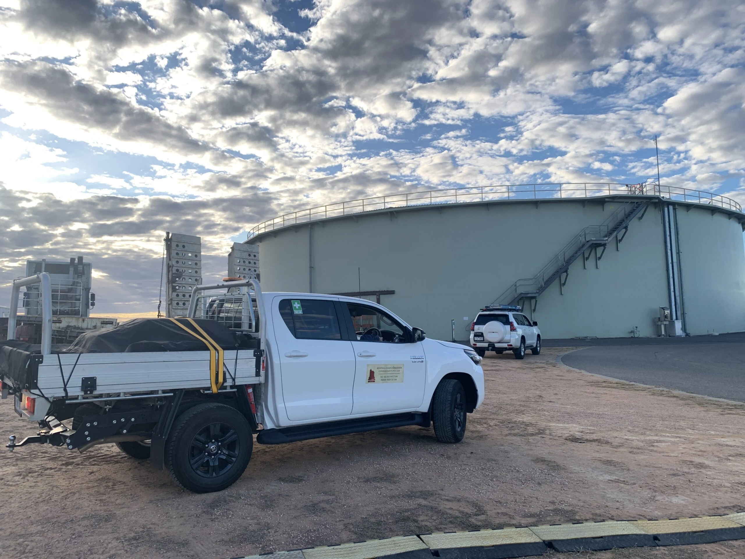 ACC service vehicles and equipment arriving at a storage tank for upgrade work